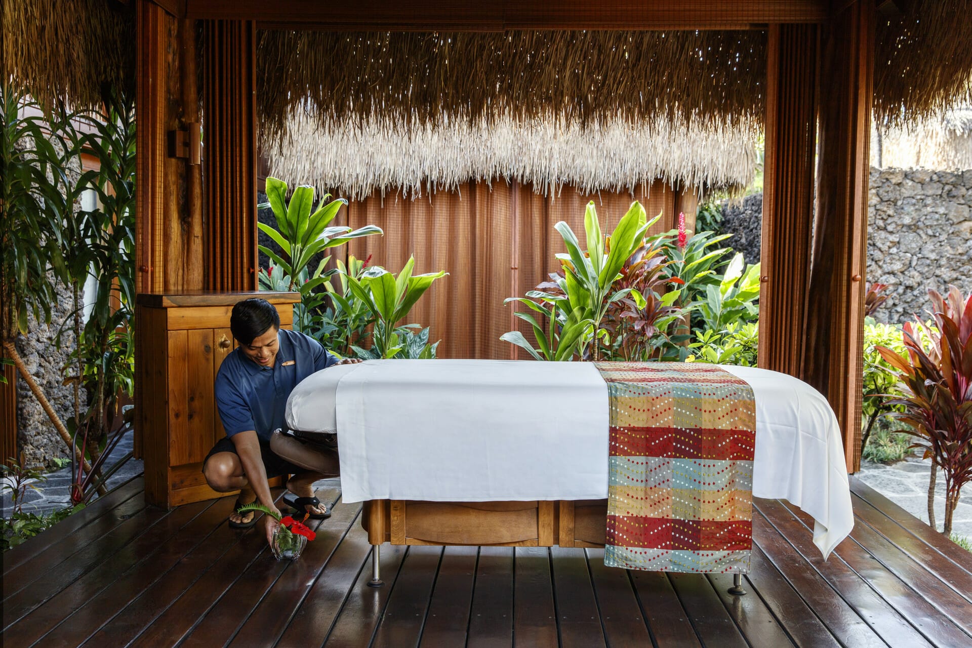 a massage therapist sets up a massage table for a massage in Kona
